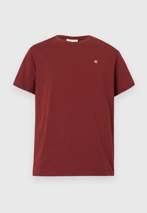 Mørkerød bomulds T-shirt med korte ærmer, rund hals og lille broderet logo på venstre bryst. Glat tekstur.