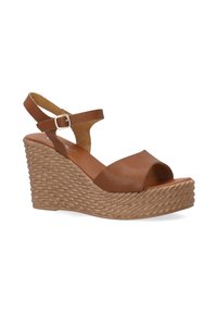 Bruine leren wedge sandalen met een gestructureerde geweven hak, open teenontwerp en verstelbare enkelband die een minimalistische stijl toont.