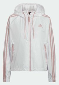 Veste à capuche blanche zippée avec logo Adidas rose, manches rayées roses et poches zippées des deux côtés.
