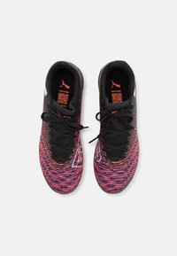 Black athletic shoes with vivid orange and purple swirling patterns, featuring a textured upper, black laces, and prominent logo accents.