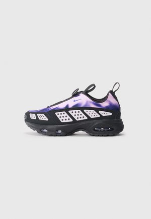 Baskets Nike avec un supérieur dégradé violet à noir, panneaux en maille, semelle noire et unité d'air visible. Conception sans lacets avec tirette.