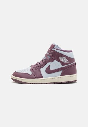 Mid-top Air Jordan -tennari, jossa valkoiset ja hillityn violetit nahkakappaleet, valkoinen Wings-logo ja kermanvärinen pohja yksinkertaista taustaa vasten.