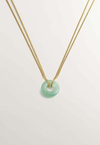Collar de doble cadena en tono dorado que presenta un colgante circular de jade verde claro con un acabado suave y translúcido.