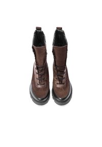 Hnědé semišové boty s polstrovaným límcem, černými gumovými podrážkami, šněrovacím designem a bočním zipem pro snadné obouvání.