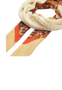 Foulard in seta con una palette di colori crema e marrone, motivi intricati e un grande nodo con estremità lunghe e fluttuanti.