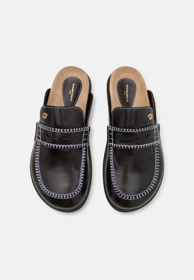 Mule in pelle nera con una finitura liscia, cuciture azzurro chiaro lungo i bordi e una soletta imbottita color cammello con logo.