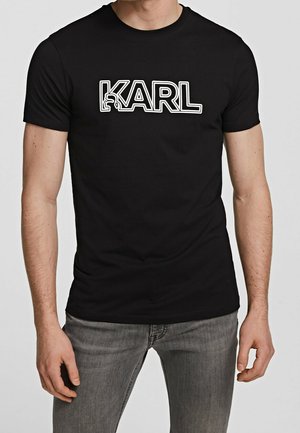 Czarny bawełniany t-shirt z wyraźnym białym napisem "KARL". Krótkie rękawy, okrągły dekolt i dopasowany krój. Prosta, gładka tekstura.