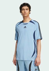 Light blue athletic shirt with black accents and three black stripes on the shoulders. Made from lightweight fabric with a textured finish.