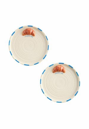 Due piatti rotondi crema con accenti blu sul bordo e un piccolo disegno di croissant vicino al bordo etichettato come "Croissant Club."