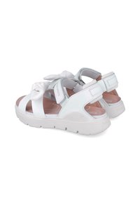 Sandalias blancas con un detalle anudado, diseño de punta abierta, correas ajustables y suelas gruesas en blanco. Material superior suave con plantilla acolchada.