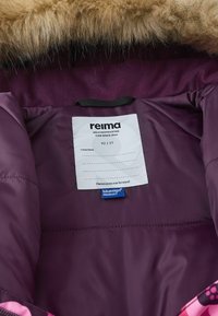 Fioletowa kurtka izolacyjna od wewnątrz z futrzanym kapturem. Posiada metkę z instrukcją pielęgnacji, metkę rozmiarową (92/2T) oraz metkę produktu bluesign®.