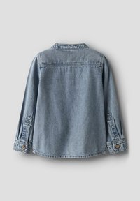 Gaiši zils džinsu jaka ar garām piedurknēm, aproces ar pogām un detaļu ar šuvi plecu daļā. Audums izskatās mīksts ar klasisku apkakles dizainu.