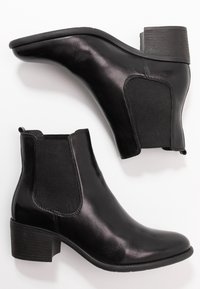 Czarne skórzane botki za kostkę z elastycznymi panelami bocznymi, niskimi, zaokrąglonymi obcasami i gładkim wykończeniem. Posiadają okrągły czubek i pętle do łatwego zakładania.