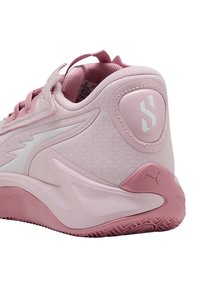 Scarpa da ginnastica rosa con tomaia in mesh, retro rotondo, dettagli bianchi, intersuola testurizzata e suola in gomma con motivo a pattern. Presenta dettaglio del logo sul tallone.