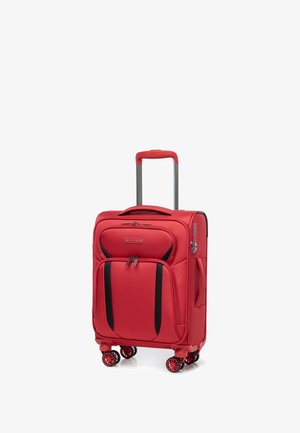 Červený kufr se čtyřmi otočnými kolečky, teleskopickou rukojetí a předními zipovými kapsami. Vyrobený z odolného materiálu, s černými akcenty.