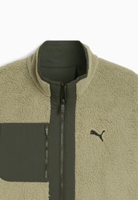 Giacca in fleece verde oliva e beige, dotata di tasca con zip sul petto, colletto alto e accento logo nero sulla parte anteriore. Superficie testurizzata.