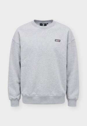 Hellgraues Sweatshirt mit Rundhalsausschnitt, gerippten Bündchen und Saum, kleiner schwarzer Patch auf der Brust mit der Aufschrift „JUVE“ und farbigen Streifen.