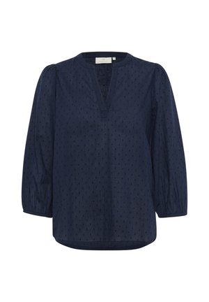 Navy blue blouse with a V-neck, puffed sleeves, and textured polka dot pattern. Lightweight fabric with a relaxed fit and curved hem.