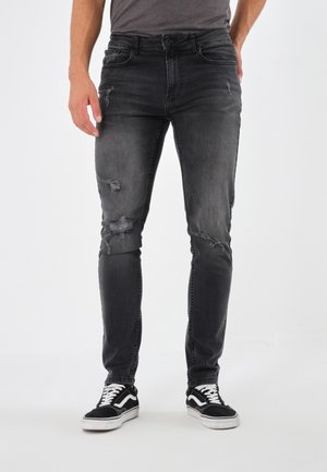 Slim-fit svarta denimjeans med slitna detaljer, med en klassisk femfickdesign, subtil blekning och knappstängning.