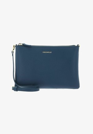 Pochette en cuir bleu marine avec sangle de poignet détachable, fermeture éclair dorée et logo COCCINELLE embossé en doré à l'avant.