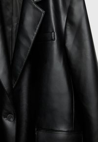 Blazer noir en cuir synthétique avec col cranté, fermeture par boutons et deux poches avant sur fond uni.