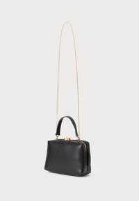 Black rectangular handbag with short leather handle and long gold chain strap, featuring a gold clasp closure on top.