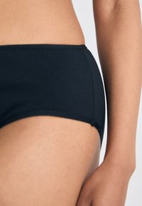 Zwarte katoenen hipsterondergoed met een zachte textuur, voorzien van een lage taille en een minimalistisch ontwerp, benadrukt door subtiele stiksels.