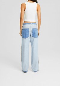 Ljusblå denimjeans med en avslappnad passform, som har två bakfickor med mörkblåa tygdetaljer och en rak bendesign.