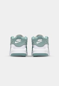 Nike Air tenisice u mint zelenoj i bijeloj boji, glatka i teksturirana gornja strana, s istaknutim logotipima na stražnjem dijelu pete.