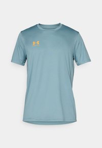 T-shirt de sport bleu clair en tissu lisse avec un col rond. Présente un logo orange sur la poitrine gauche et des manches courtes.
