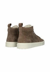Brune ruskind højtopsneakers med hvide gummisåler, snørebånd foran og løkker bagpå. Har præget logo på siden.