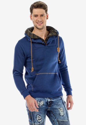 Blauer Baumwollhoodie mit einem gemusterten Innenfutter, vordere Tasche, verstellbaren Kordeln und kontrastierenden braunen Akzenten.