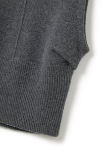 Primo piano di un gilet senza maniche in lana grigia scura che mostra una texture morbida e un orlo a coste su uno sfondo bianco.