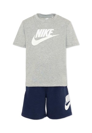 Szara koszulka Nike z krótkim rękawem i białym logo zestawiona z granatowymi szortami Nike z białym logo na lewym udzie.