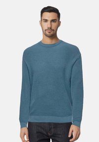 Maglione blu a girocollo in morbido materiale lavorato a maglia, con maniche lunghe, vestibilità comoda e polsini e orlo a costine. Texture liscia, senza motivi.