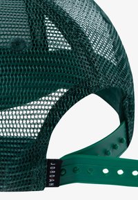 Gorra de malla verde con un diseño estructurado, cierre de plástico en la parte trasera y una etiqueta tejida. La malla proporciona ventilación y contraste de textura.