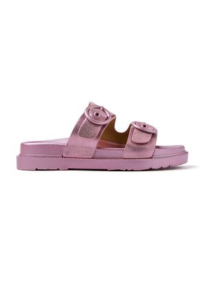 Sandale slide rose avec deux boucles circulaires, texture lisse et semelle plate. Caractérisée par un design léger et une finition subtilement pailletée.