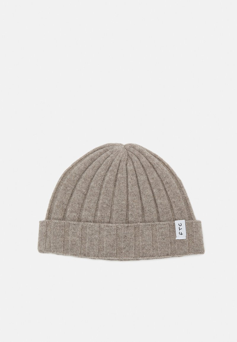 Szara czapka beanie z prążkowanego materiału, z podwiniętym brzegiem i małą białą metką z czarnym napisem. Miękka tekstura i zaokrąglony kształt.