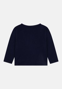 Top à manches longues bleu marine en tissu doux, avec un col arrondi et des bords finis. Design minimaliste sans détails supplémentaires.