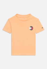 Πορτοκαλί κοντομάνικο μπλουζάκι από βαμβάκι. Διαθέτει κυκλικό γράφημα σε μαύρο, κόκκινο και λευκό στο στήθος. Δύο κουμπιά τύπου πατιλέτα στον ώμο.