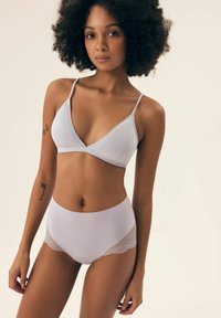Light purple wireless bralette with a ribbed texture; matching high-waisted briefs feature geometric lace side panels.