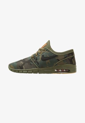 Zapatilla deportiva de perfil bajo con empeine de malla de camuflaje, suela verde oliva, logo Nike negro y amortiguación de aire visible en el talón.