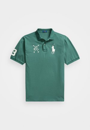 Polo en coton vert avec un col classique, des manches courtes, et des logos et un numéro brodés à l'avant et sur la manche.