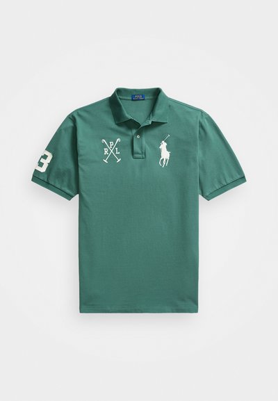 Polo de algodón verde con cuello clásico, mangas cortas, y logos bordados y número en el frontal y la manga.