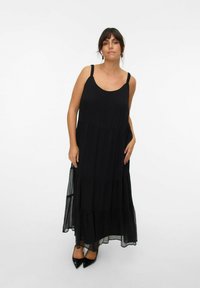 Robe maxi noire au design fluide, avec des couches en éventail. Fabriquée en tissu léger avec des bretelles réglables et un décolleté rond.