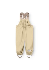 Salopette impermeabile beige con spallacci incrociabili regolabili, polsini elastici e una toppa riflettente con logo sul lato. Texture liscia e design senza cuciture.