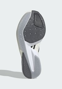 Zwart-wit sport schoen zool met een getextureerde rubberen grip, een gladde tussenzool en zichtbare branding aan de zijkant en hiel.
