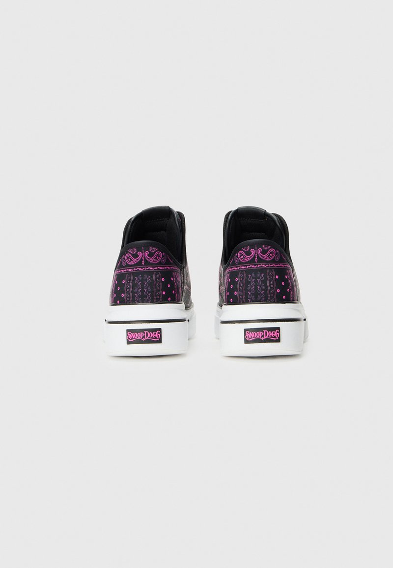 Sneaker nere con dettagli viola, caratterizzate da pattern intricati e una suola in gomma bianca. Logo sul tallone. Forma standard delle sneaker.