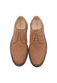 Beige Wildleder Schnürschuhe mit runder Zehenpartie, minimalistischem Design, kontrastierender dunkelbrauner Sohle und dezenten Nähdetails.