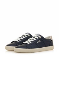 Sneakers in pelle blu nautico con lacci bianchi, suola beige e branding sul lato. Punta arrotondata e design sleek a low-top.
